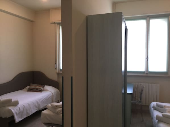 Un dormitorio con una cama, un escritorio y una silla.
