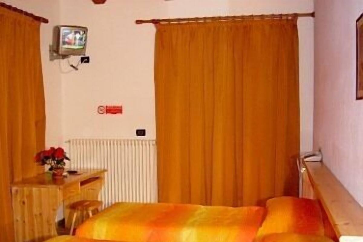 A room with a bed, a desk, and a radiator.