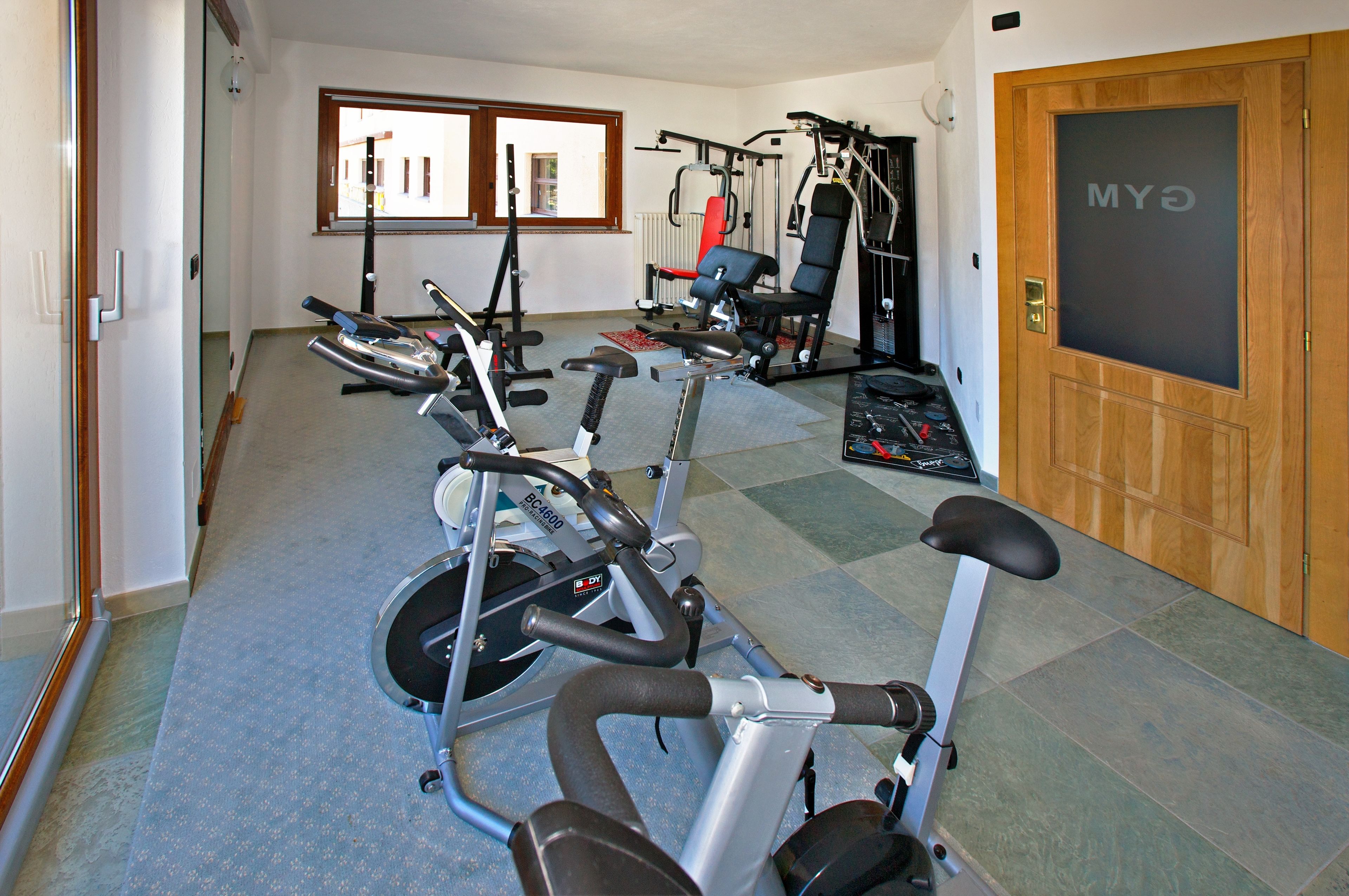A gym with exercise bikes, a treadmill, and weight machines.