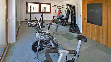 A gym with exercise bikes, a treadmill, and weight machines.