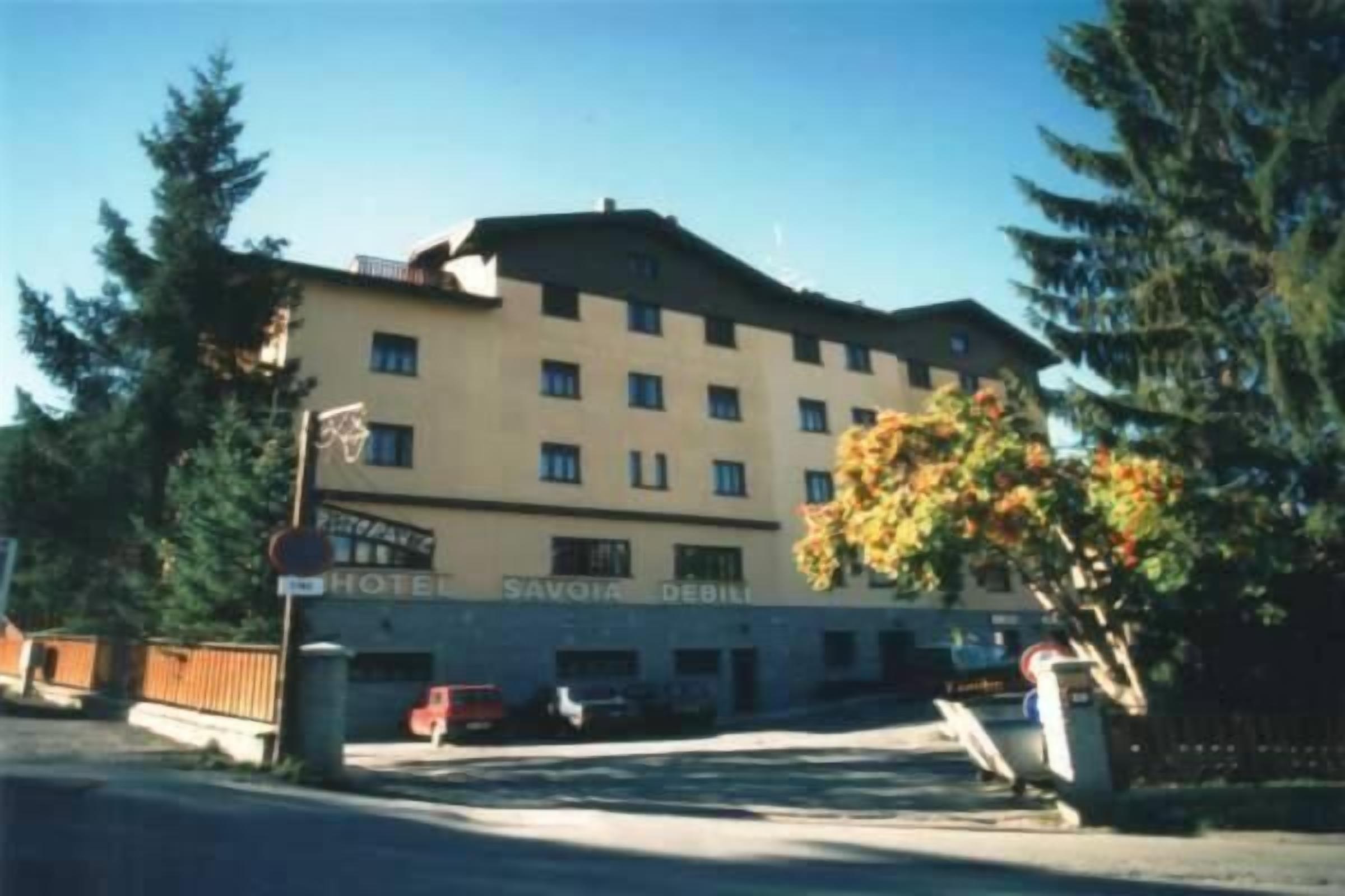 A multi-story hotel with a sign reading "HOTEL SAVORIA DEBILI".