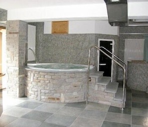 A stone-floored bathroom with a built-in hot tub, a shower area, and a small window. - Savoia Debili (Sauze d'Oulx)