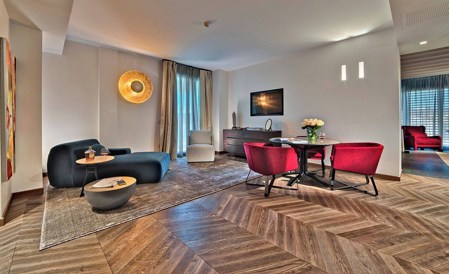 Un salon moderne avec un canapé, un pouf et une table à manger avec des chaises.