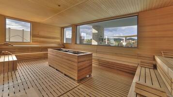 A wooden sauna with large windows and a stone wall.