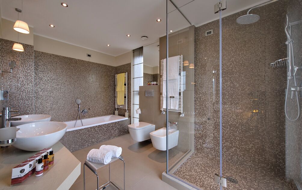 A modern bathroom with a large sink, a bathtub, a shower, and a glass-enclosed shower area.