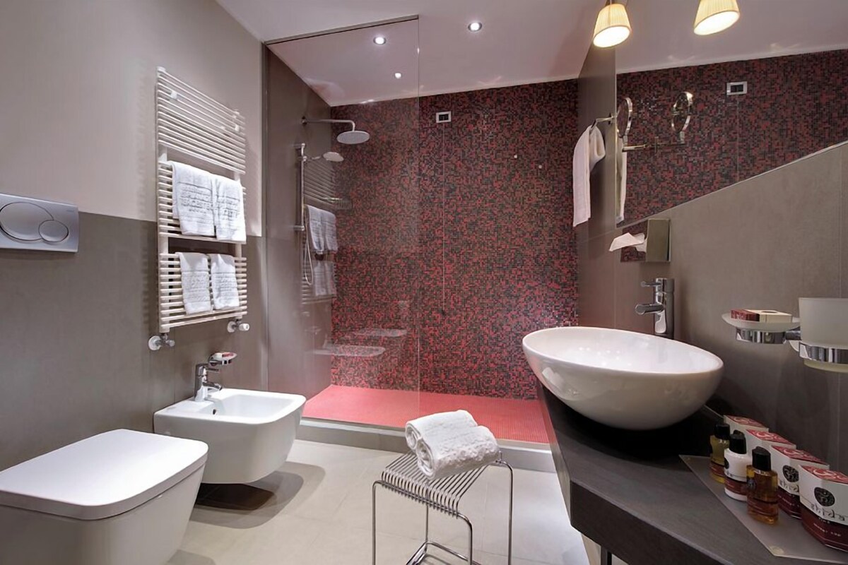 A modern bathroom with a large sink, bidet, and shower.