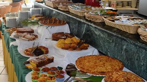 Un buffet proposant une variété de produits de boulangerie, notamment des gâteaux, des tartes et des muffins, disposés sur des tables.