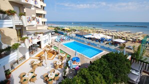 Un hôtel doté d’une piscine, d’un espace extérieur aménagé et offrant une vue sur la plage.