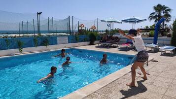 Una piscina al aire libre, sillones reclinables de piscina