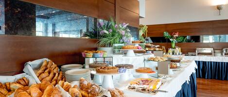 A buffet with various baked goods and desserts.