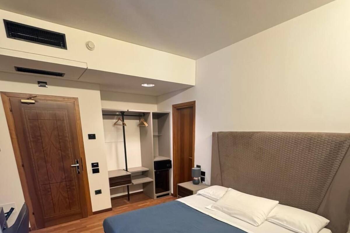 Un dormitorio con cama, armario, escritorio y silla.