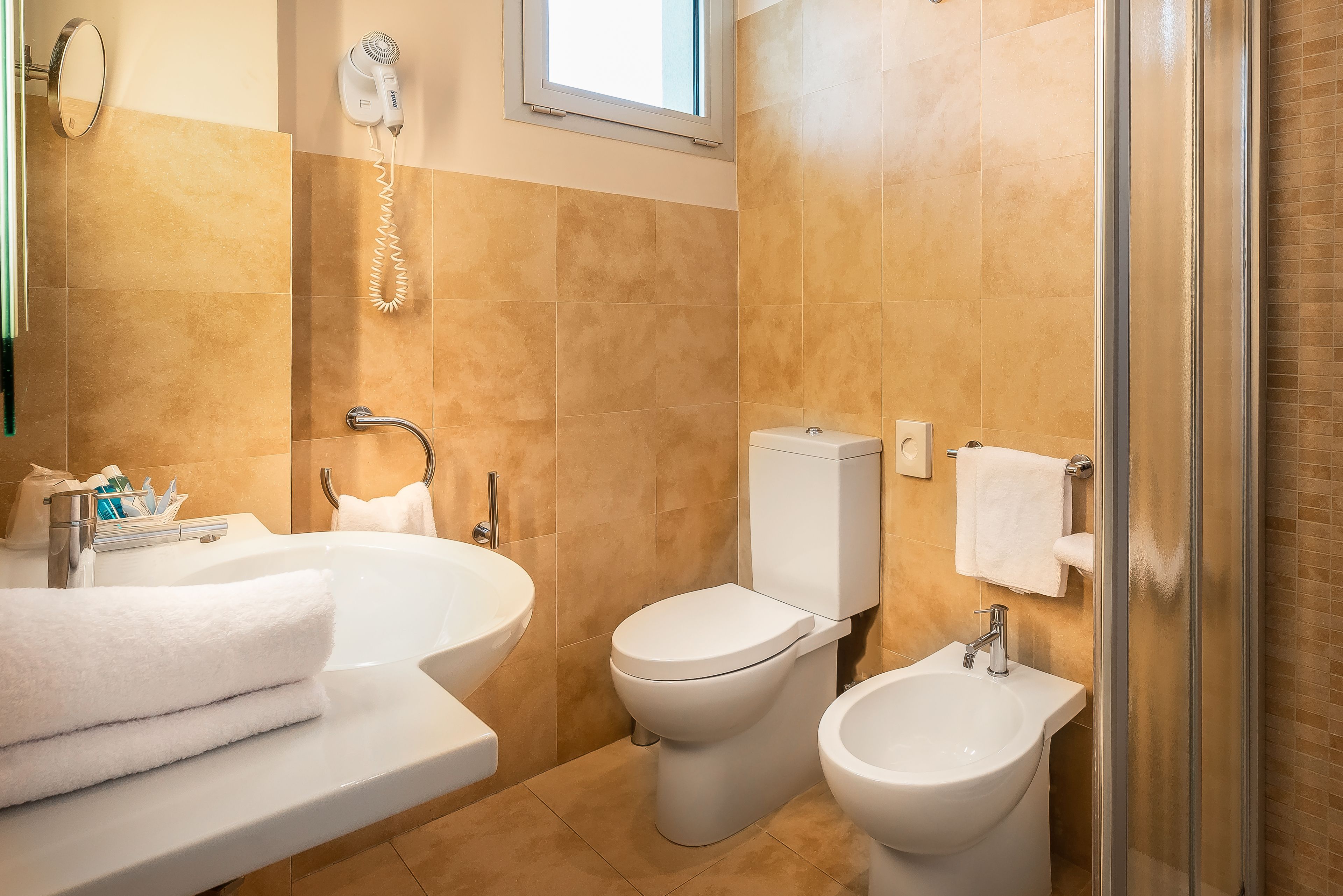 A bathroom with a bathtub, a toilet, a bidet, and a shower.
