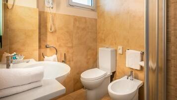 A bathroom with a bathtub, a toilet, a bidet, and a shower.