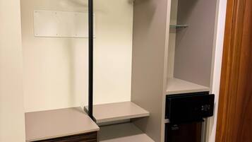 Un dressing avec des cintres en bois, un appareil électroménager noir et un meuble en bois.