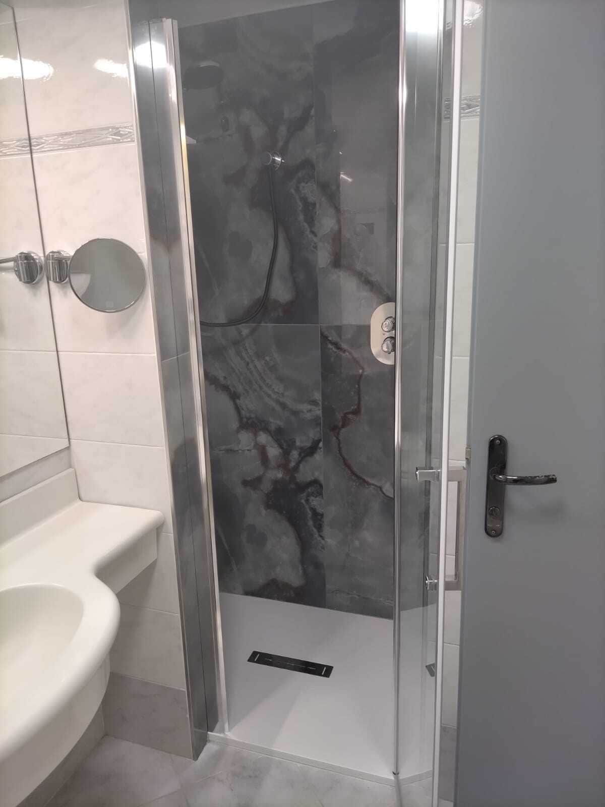 Une salle de bain avec une douche, des toilettes et un lavabo.