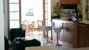 A modern kitchen with a bar area, a dining table with chairs, and a large window. - Gala (Pesaro)