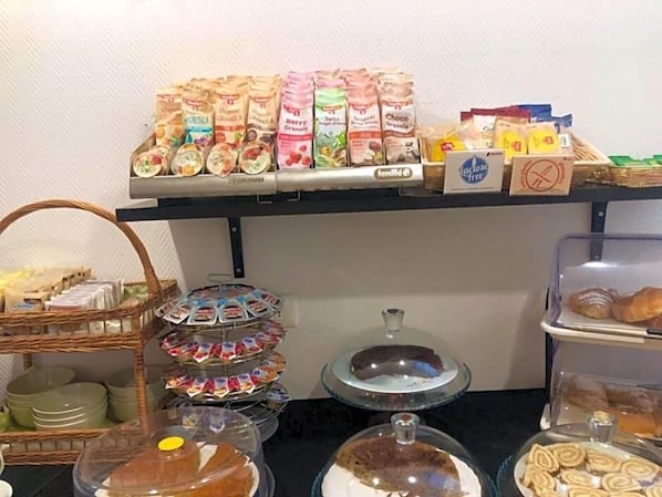 Un bufé de desayuno con diferentes alimentos y recipientes.