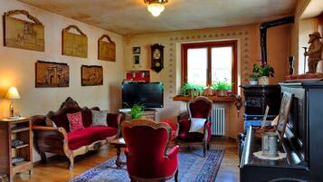 A traditional living room with a fireplace, wooden furniture, and decorative wall art.