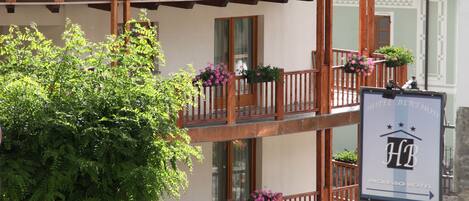 Un hotel de varios pisos con balcones, fachada de piedra y un letrero que indica que es un Ingresso Hotel.