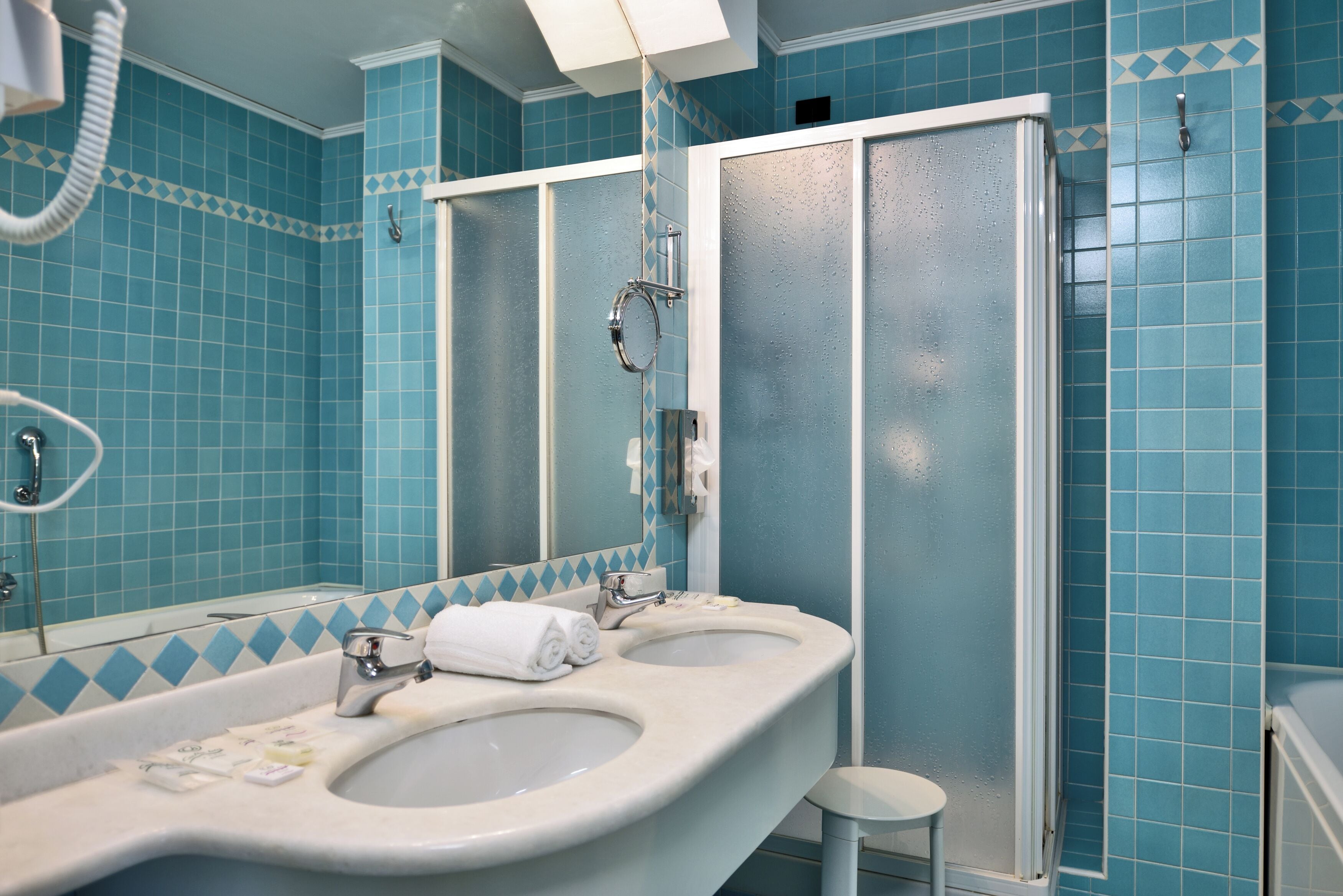Une salle de bain avec deux lavabos, un miroir et une douche.