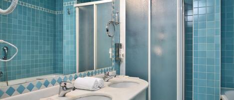 Une salle de bain avec deux lavabos, un miroir et une douche.