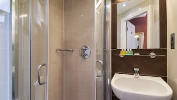A modern bathroom with a glass-enclosed shower, a white sink, and a mirror above it.