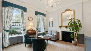 A living room with a fireplace, a chandelier, and a large mirror.
