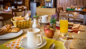 A breakfast setting with bread, pastries, a cup of coffee, an apple, and a glass of orange juice on a table. - Hotel Ferretti (Florence)