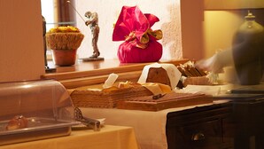 Un buffet garni de divers plats, agrémenté d’un vase décoratif et d’une statue.