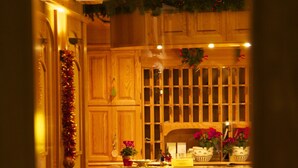 Une cuisine en bois avec un tapis rouge, des meubles de rangement en bois et des décorations de Noël.