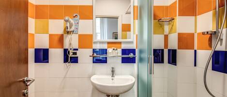 A bathroom with a white sink, a mirror, and a shower.