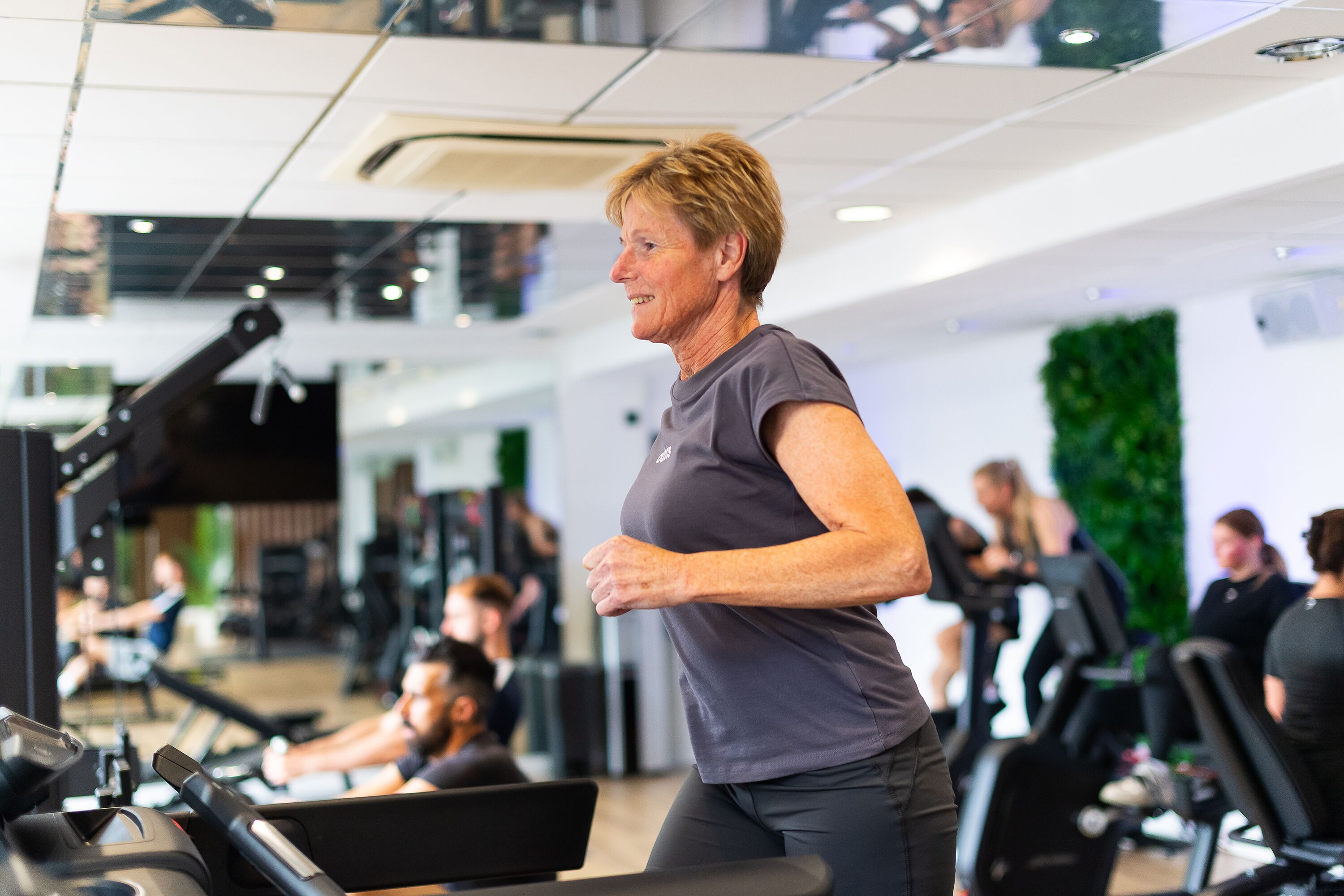 Een sportschool met loopbanden en fitnessapparatuur.