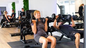 Una palestra con attrezzature per esercizi, tra cui manubri e panche.