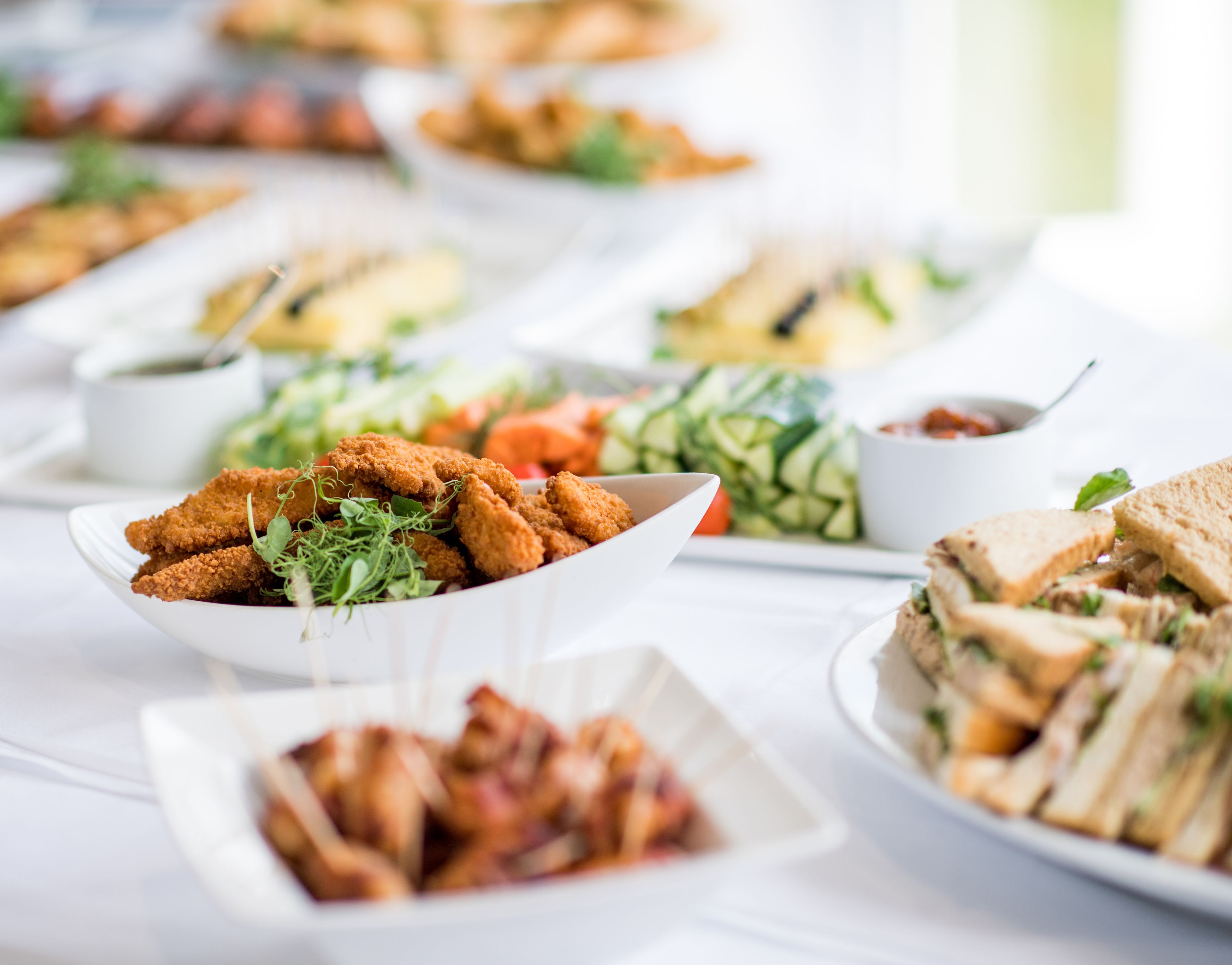A buffet table with various dishes including fried items, salads, and sandwiches.
