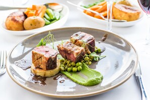 A plate of food with meat, peas, and a green sauce. - The Barnstaple Hotel (Barnstaple)