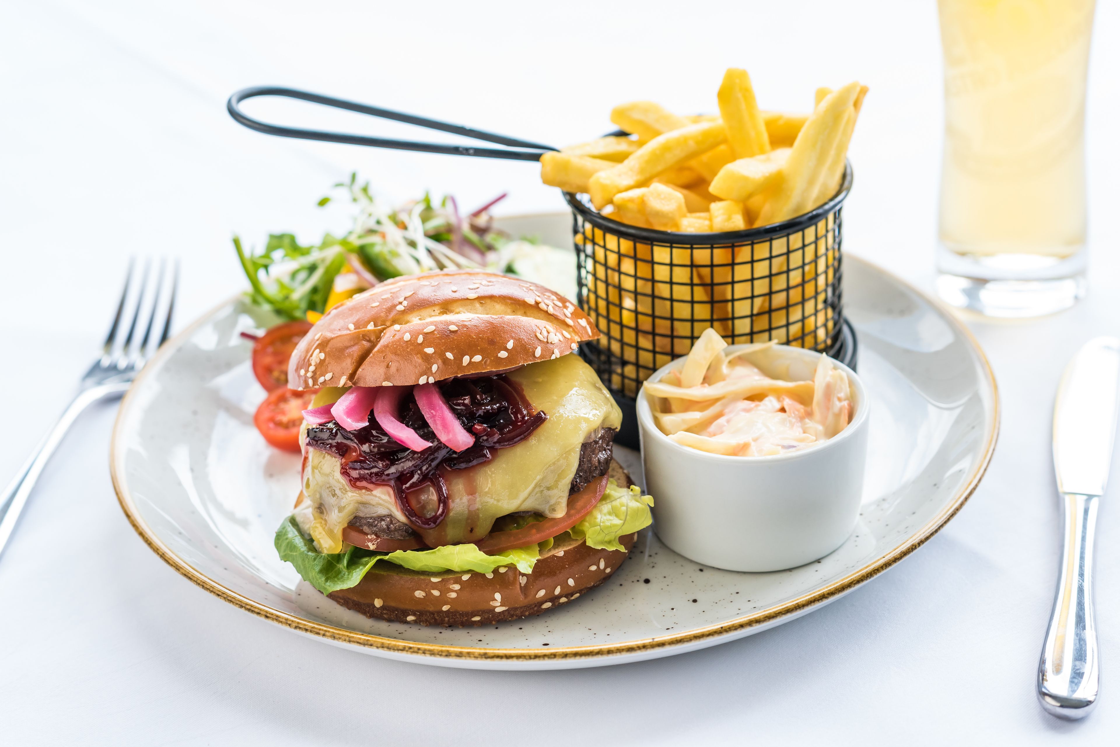 Un plato con una hamburguesa, papas fritas y ensalada.