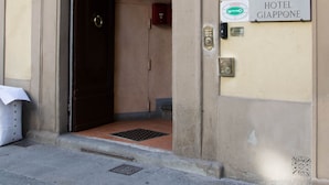 Entrada de un hotel con un arco decorativo y letreros que dicen 'Hotel Giappone' y 'Abaco'.