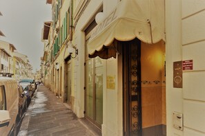 A narrow street with parked cars and a hotel with a sign reading "HOTEL PALAZZOLO." - Hotel Palazzuolo (Florence)