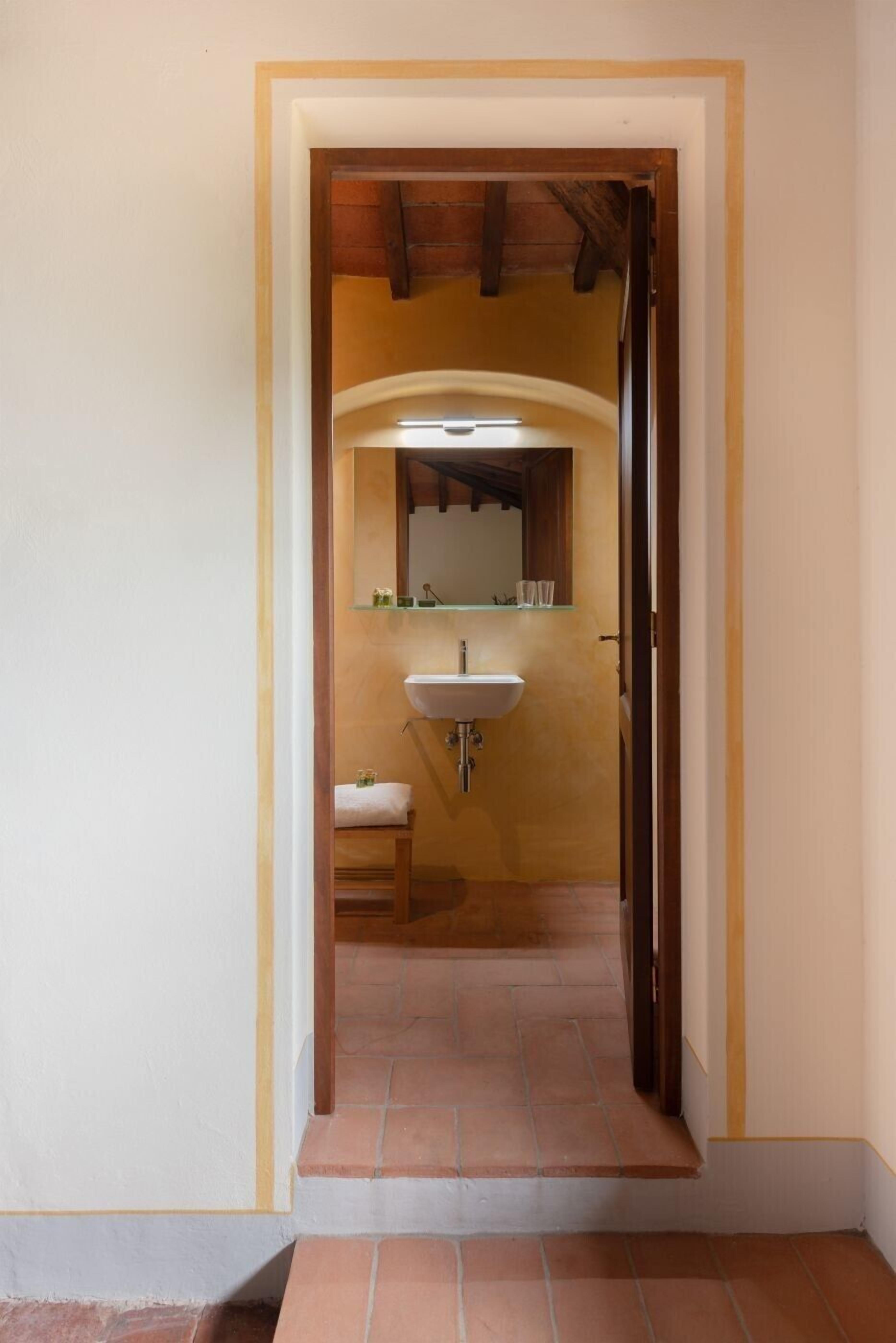 A bathroom with a white sink, a mirror, and a towel rack.