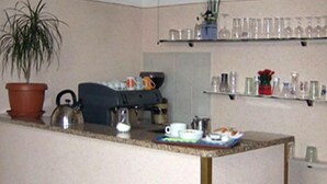 A kitchen area with a counter, a potted plant, and a kettle. There are two paintings on the wall above the counter. - Hotel Cordova (Florence)
