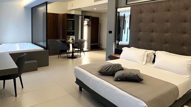 Une chambre d’hôtel moderne dotée d’un grand lit, d’un bureau et d’un coin salon.