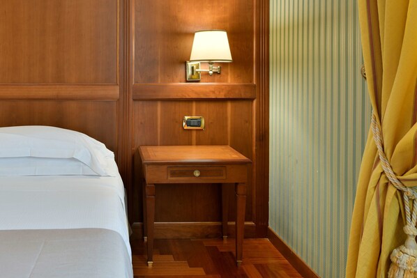 A wooden bedside table with a lamp, a bedside drawer, and a wall-mounted thermostat. - Best Western Hotel Ferrari (San Vitaliano)