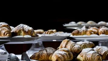 Une variété de viennoiseries, notamment des croissants, présentées sur des plateaux.