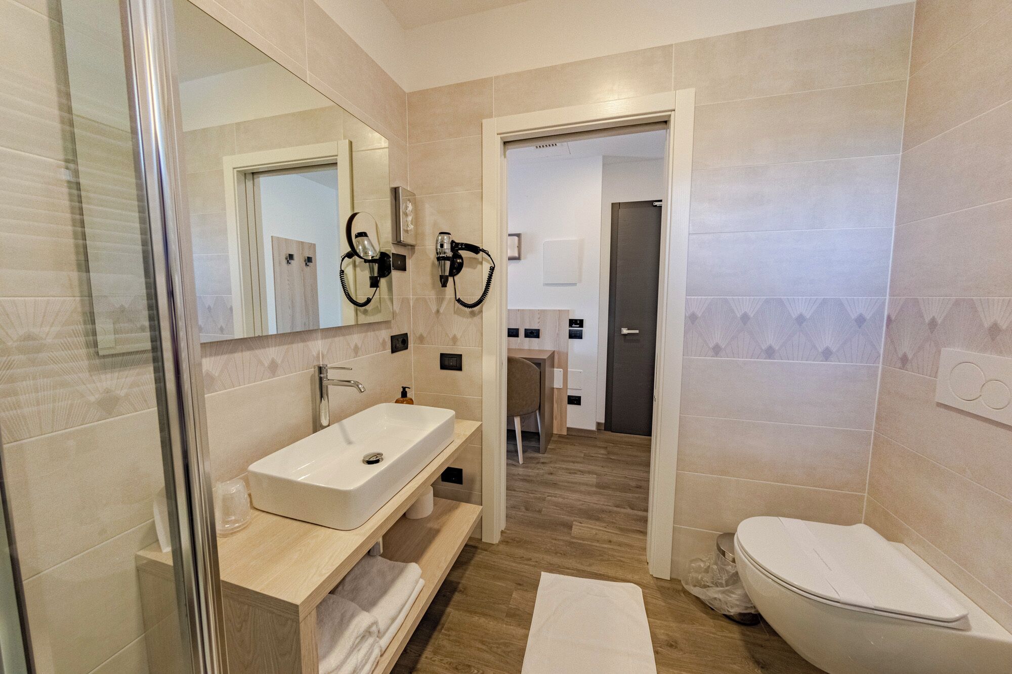 Une salle de bain moderne avec un lavabo, un miroir et des toilettes.