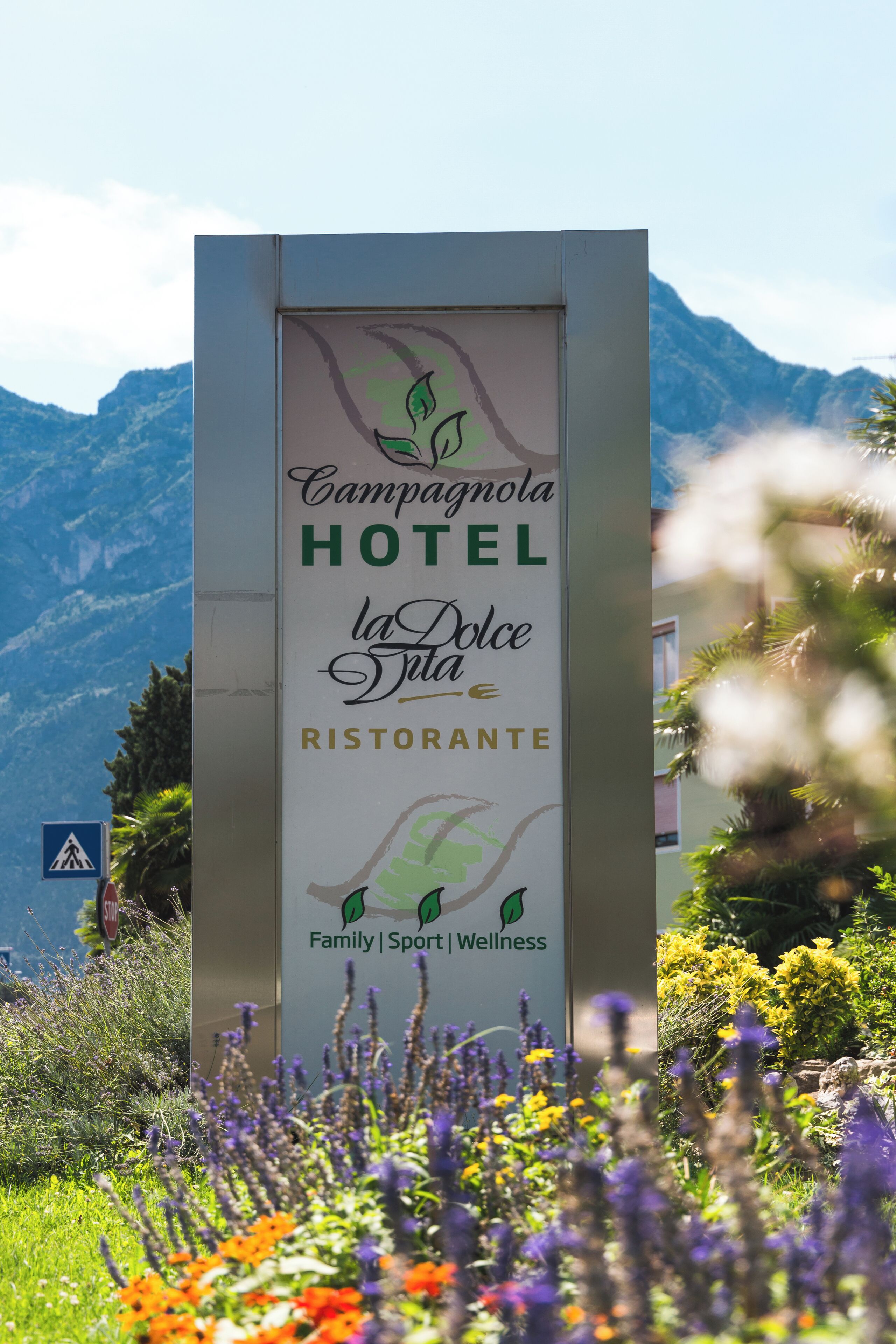 A sign for Campagnola Hotel with a mountain backdrop.