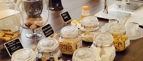 A buffet table with various food items in jars and a potted plant.