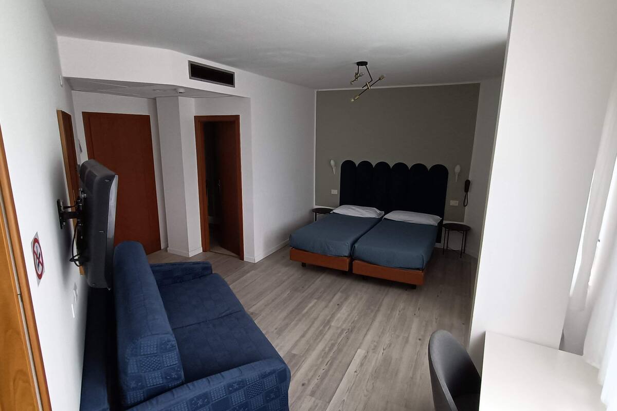 Une chambre à coucher avec un lit, un canapé, un bureau et une chaise.