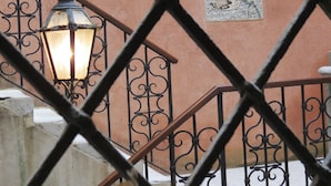 A staircase with wrought iron railings and a wall-mounted mosaic. - Hotel Bridge (Venice)