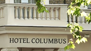 Un immeuble sur lequel on peut lire l’inscription « HÔTEL COLUMBUS ».