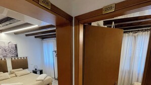 A hotel room with a bed, a bedside table, and a wall-mounted TV. - Albergo Marin (Venice)